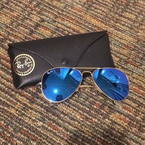 Blue mirror ray bans with a gold rim